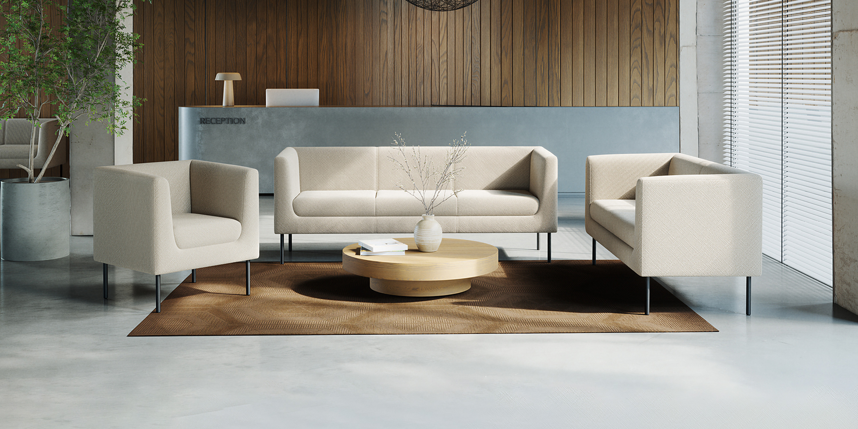 Helle Polstermöbel Quadra mit Sessel und Sofa auf Teppich vor einer Holz und Betonwand in einem Empfangsbereich